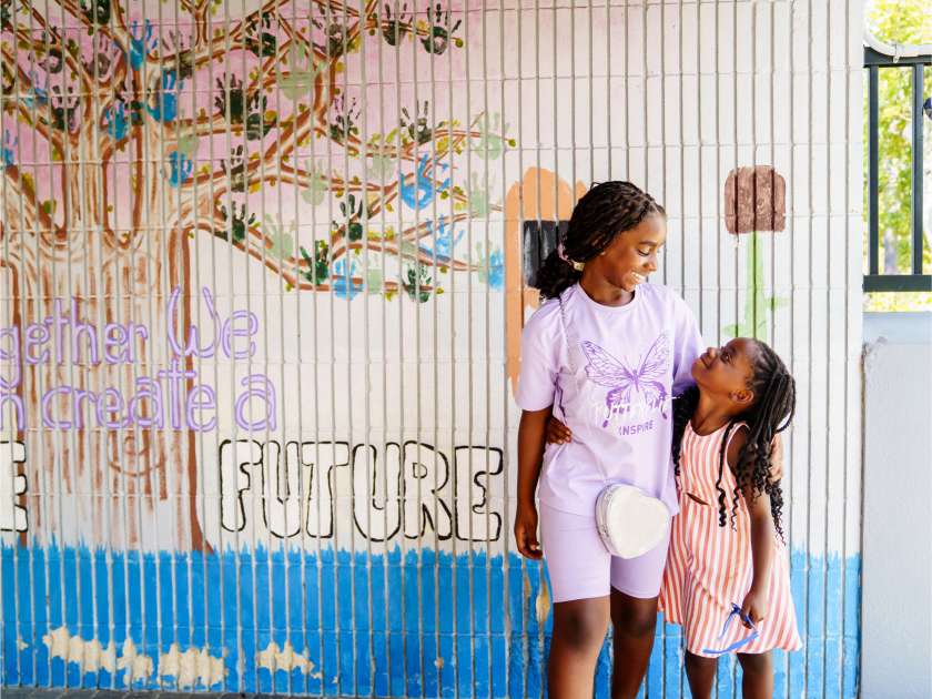 Girls standing next to a wall mural