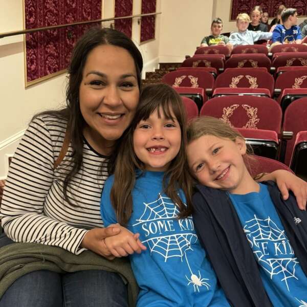 A teacher and two students smiling on a field trip to the Barter Theater